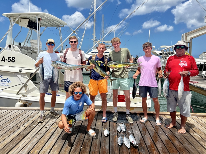 Group of friends enjoying a fishing trip on a boat in Aruba with Carla Charters