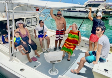 Family enjoying a fishing trip on a boat in Aruba with Carla Charters